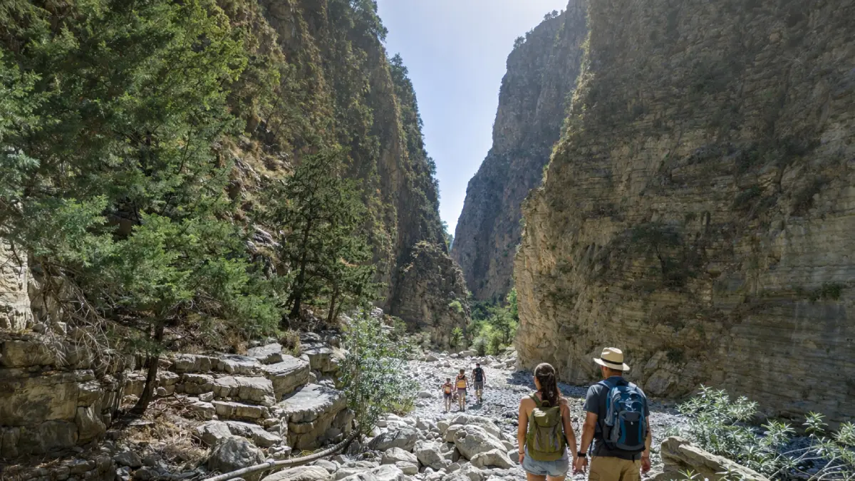 Droga w Wąwozie Samaria na Krecie: kamienisty szlak prowadzący przez najdłuższy wąwóz Europy, widok na wysokie formacje skalne pod czystym błękitnym niebem.